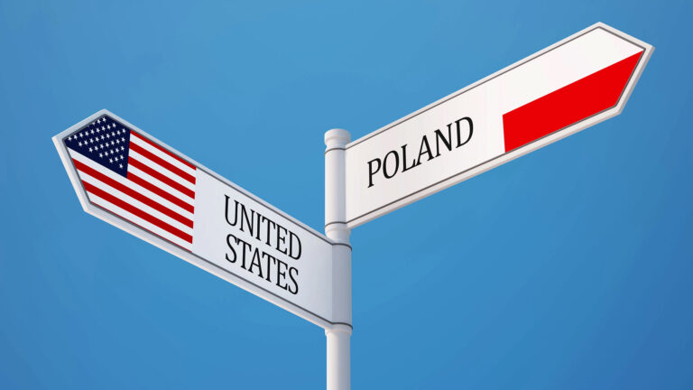 Drogowskaz z flagami Polski i USA, symbol wyboru między dwoma krajami
