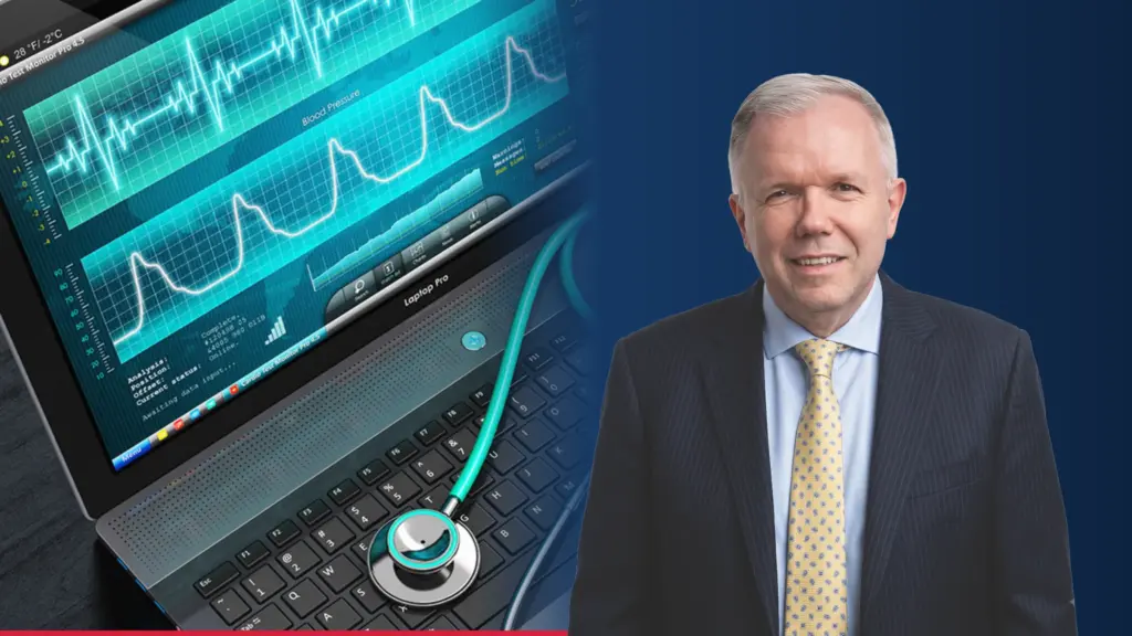 Dr Adam S. Budzikowski, kardiolog, obok zdjęcia monitora z zapisem pracy serca