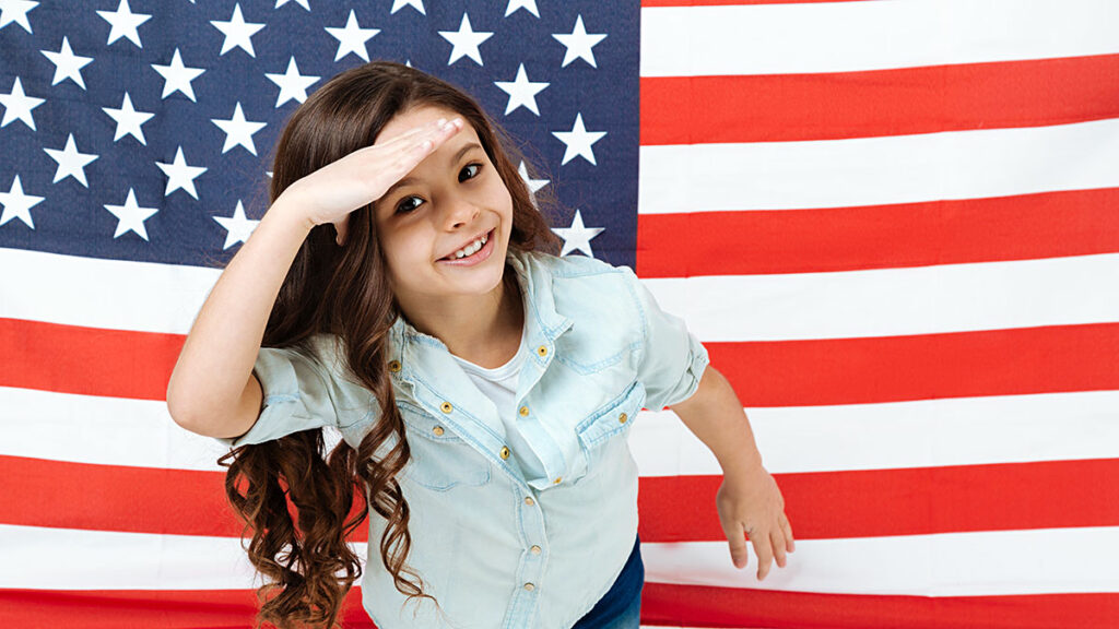 Girl saluting in front of the U.S. flag – U.S. citizenship for a child born in Poland