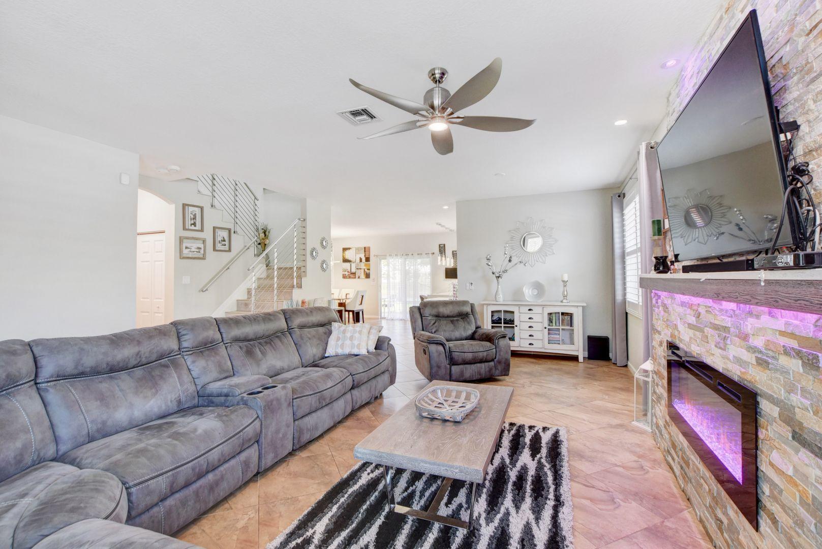 Salon z elektrycznym kominkiem w domu przy 8890 Cobblestone Point Circle, Boynton Beach