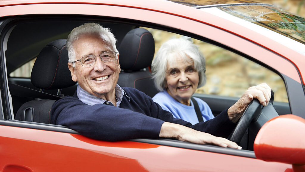 Smiling senior couple in a car – car insurance discounts for seniors