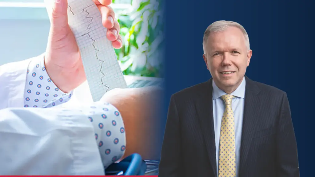 Dr Adam S. Budzikowski, kardiolog, obok zdjęcia zapisu EKG