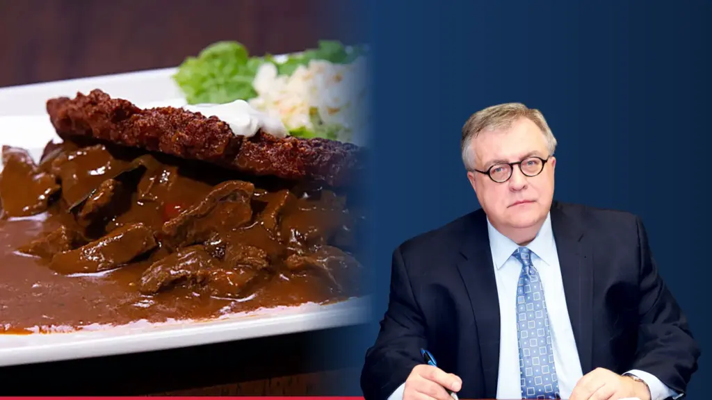 Adwokat Robert Wisniewski obok talerza z daniem restauracyjnym – napiwki i płace w gastronomii