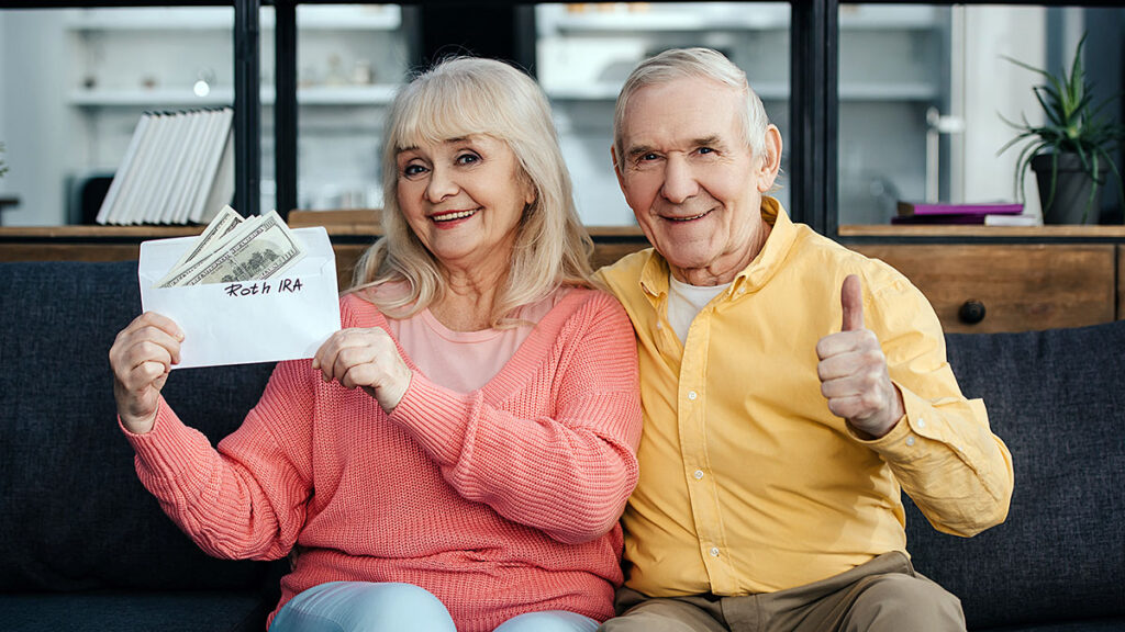 Senior couple holding a check at home – required minimum distributions (RMD) from IRAs