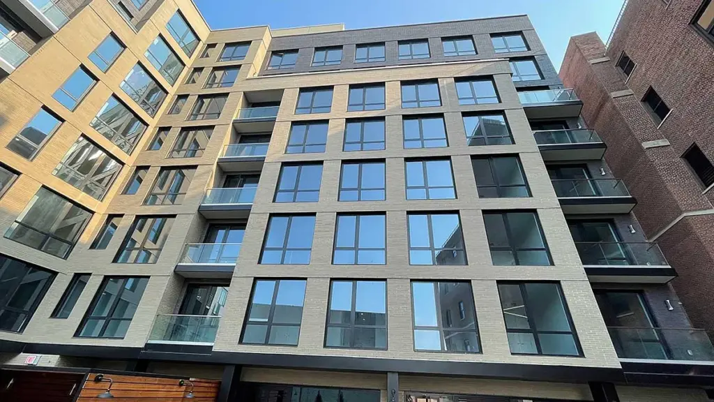 New multi-story multifamily building in New York with large windows and balconies
