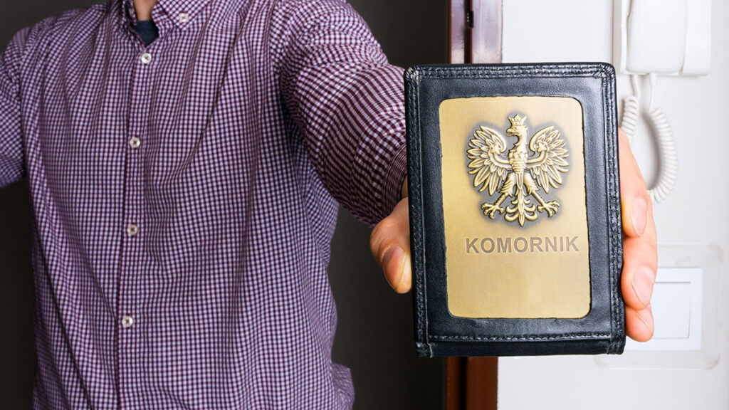 Man holding a badge with the Polish eagle – how much a Polish bailiff can take from a pension