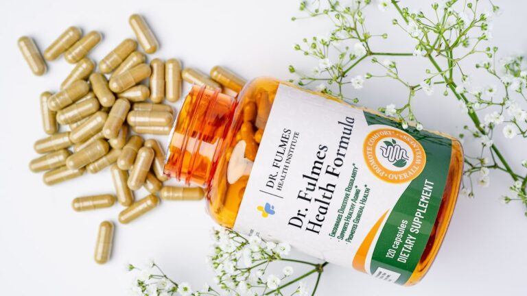 Butelka suplementu Dr. Fulmes Health Formula z rozsypanymi kapsułkami i gałązkami gipsówki