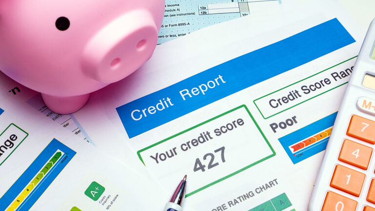 Piggy bank and a credit report with a low 427 score – a spouse's bad credit history